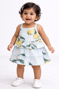 Baby girl wearing a lemon print tiered cotton frock in light blue