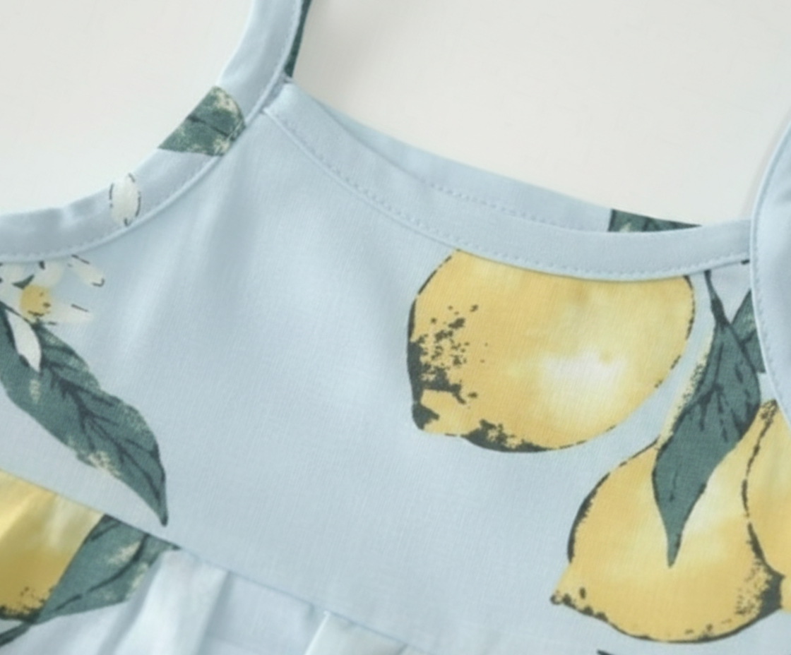 Close-up view of lemon print detail on Baby Girls Zesty Lemon Tiered Cotton Frock