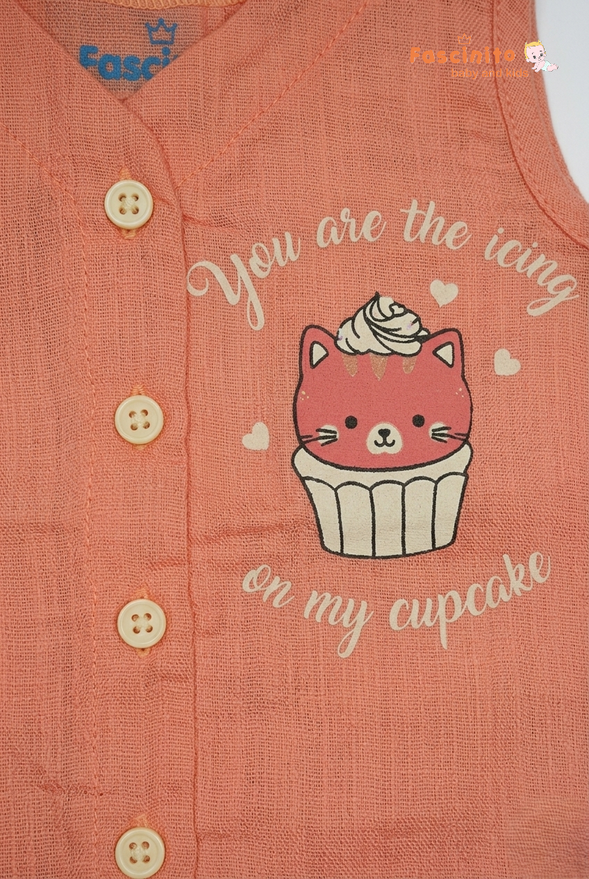 Close-up of cupcake kitten print and front button detail on peach baby jhabla top