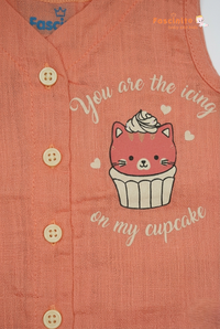 Close-up of cupcake kitten print and front button detail on peach baby jhabla top