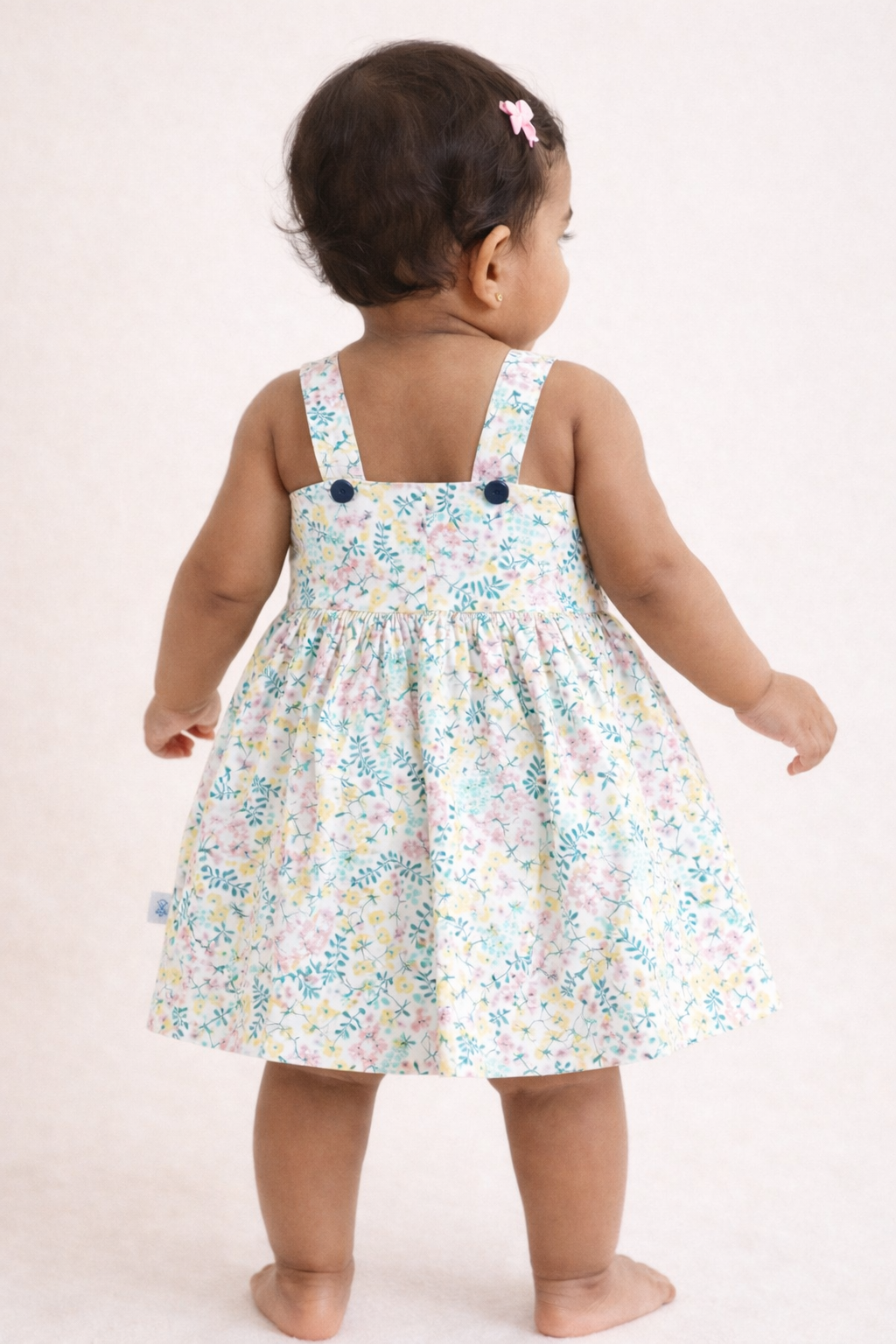 Back view of girls floral woven sleeveless cotton frock with all-over floral print